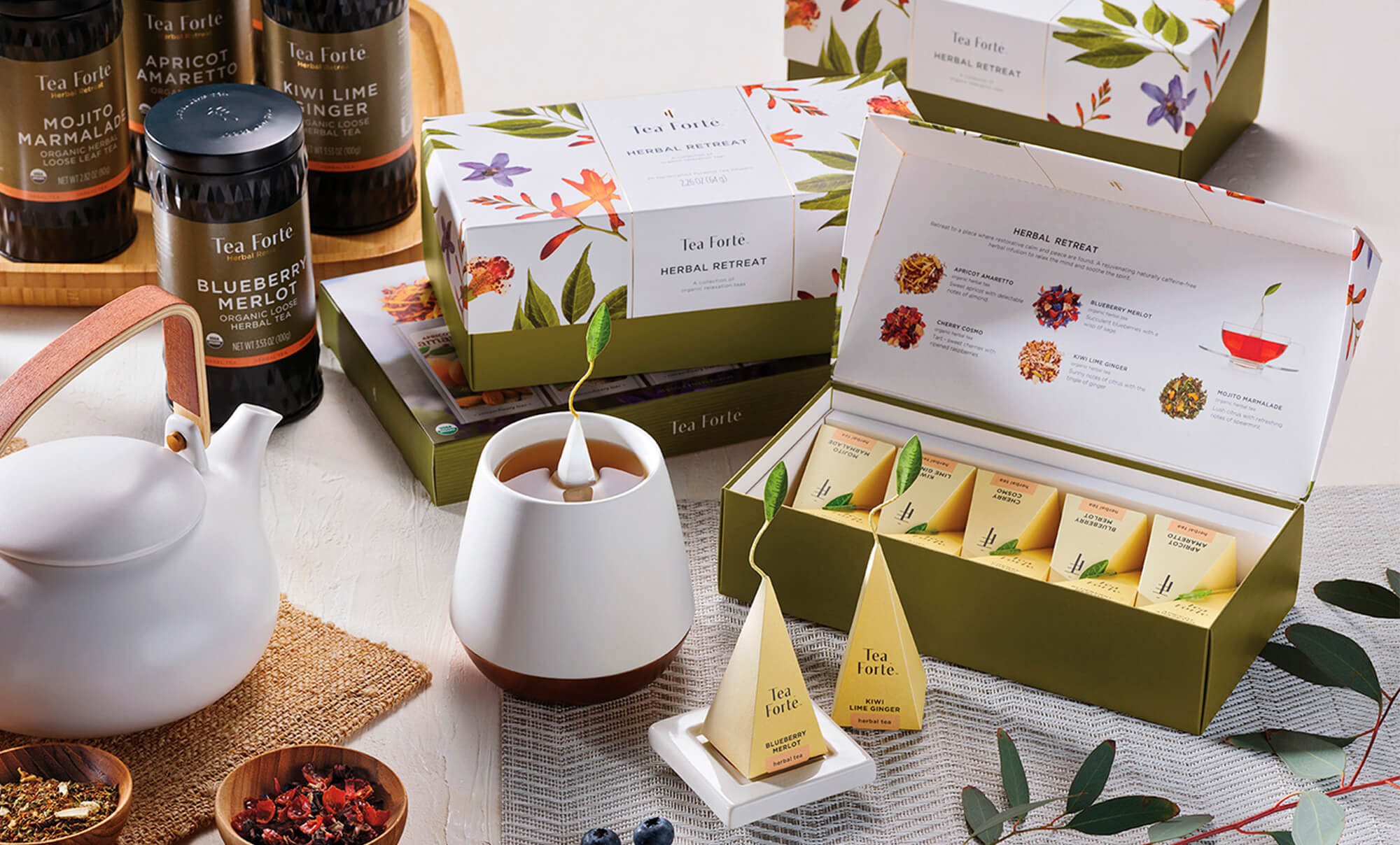 Herbal Retreat collection and white accessories on a table with leaves and loose tea