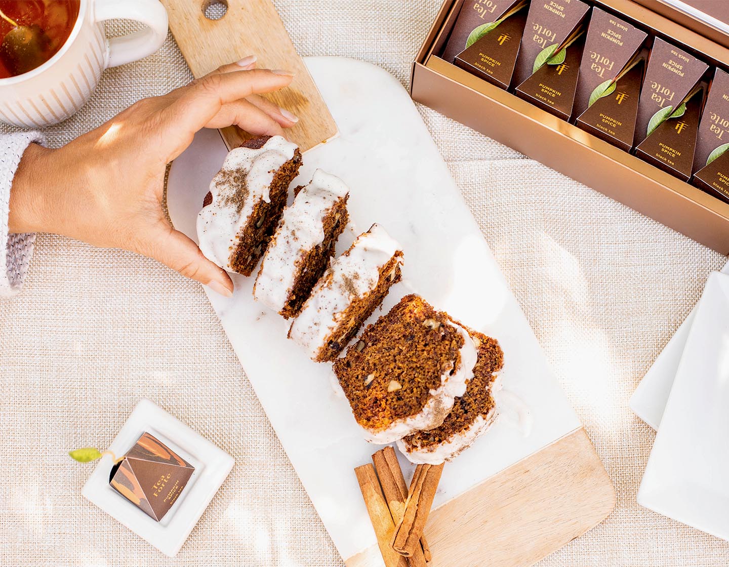 Taking a slice of frosted Pumpkin Spice Tea Loaf