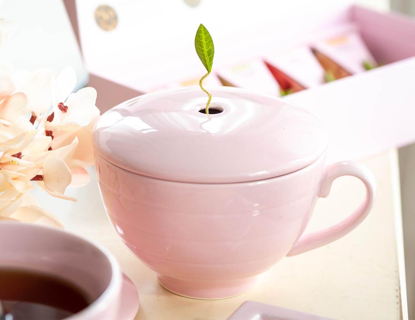 Rose Pink Café Cup with cover on a table with other pink teas.