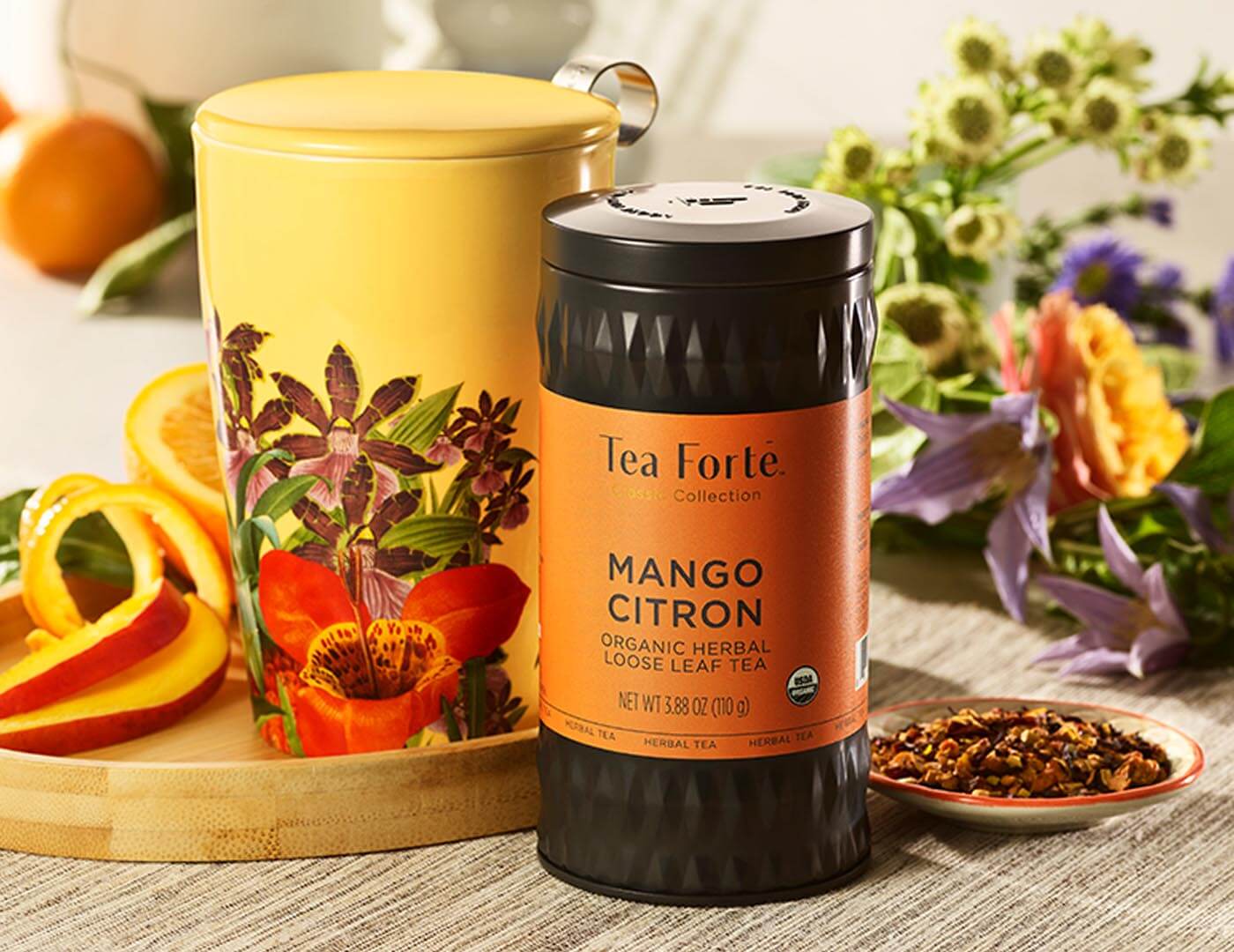 Image of Mango Citron Tea Canister next to cup