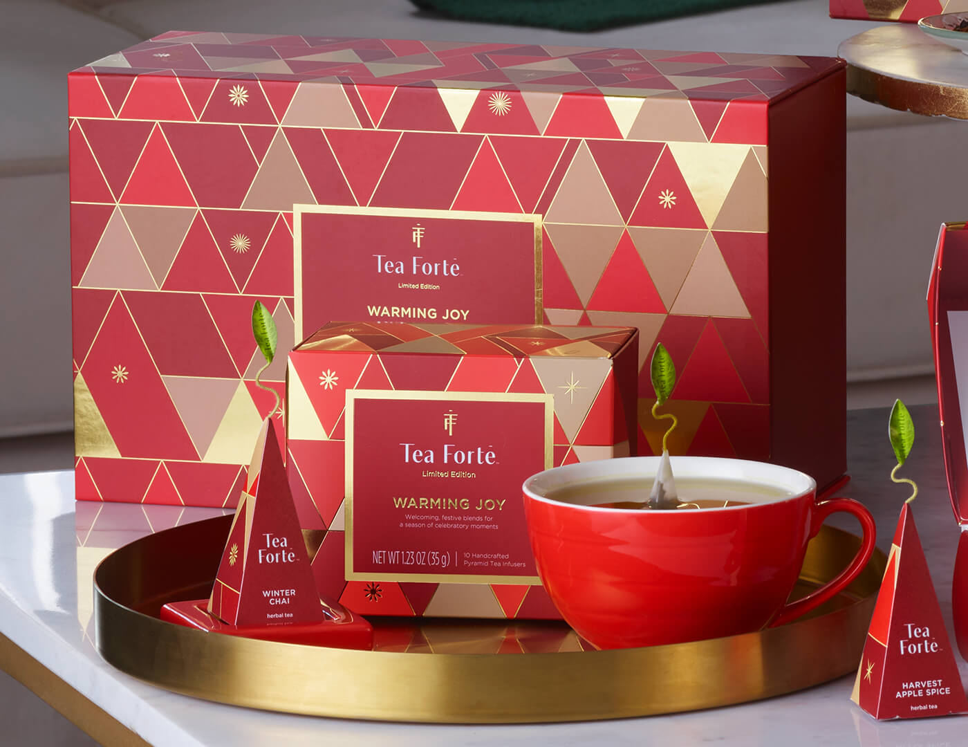 Warming Joy Gift Set on a white table, contents arranged inside a gold tray