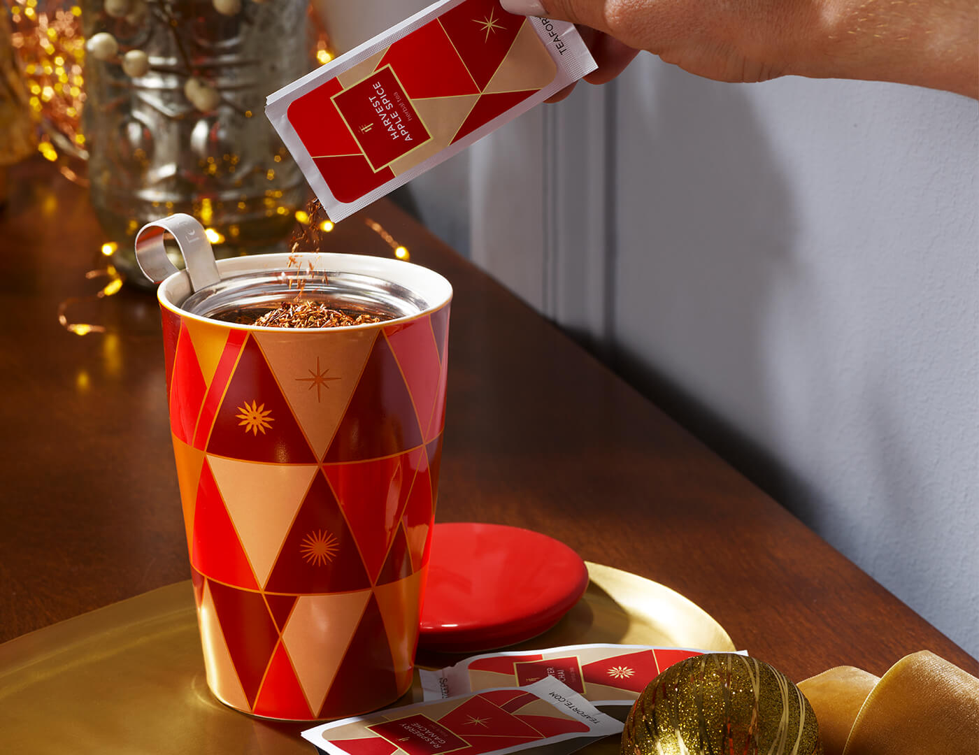 Pouring a single steep pouch into the Warming Joy KATI Steeping Cup on a gold tray with single steeps below