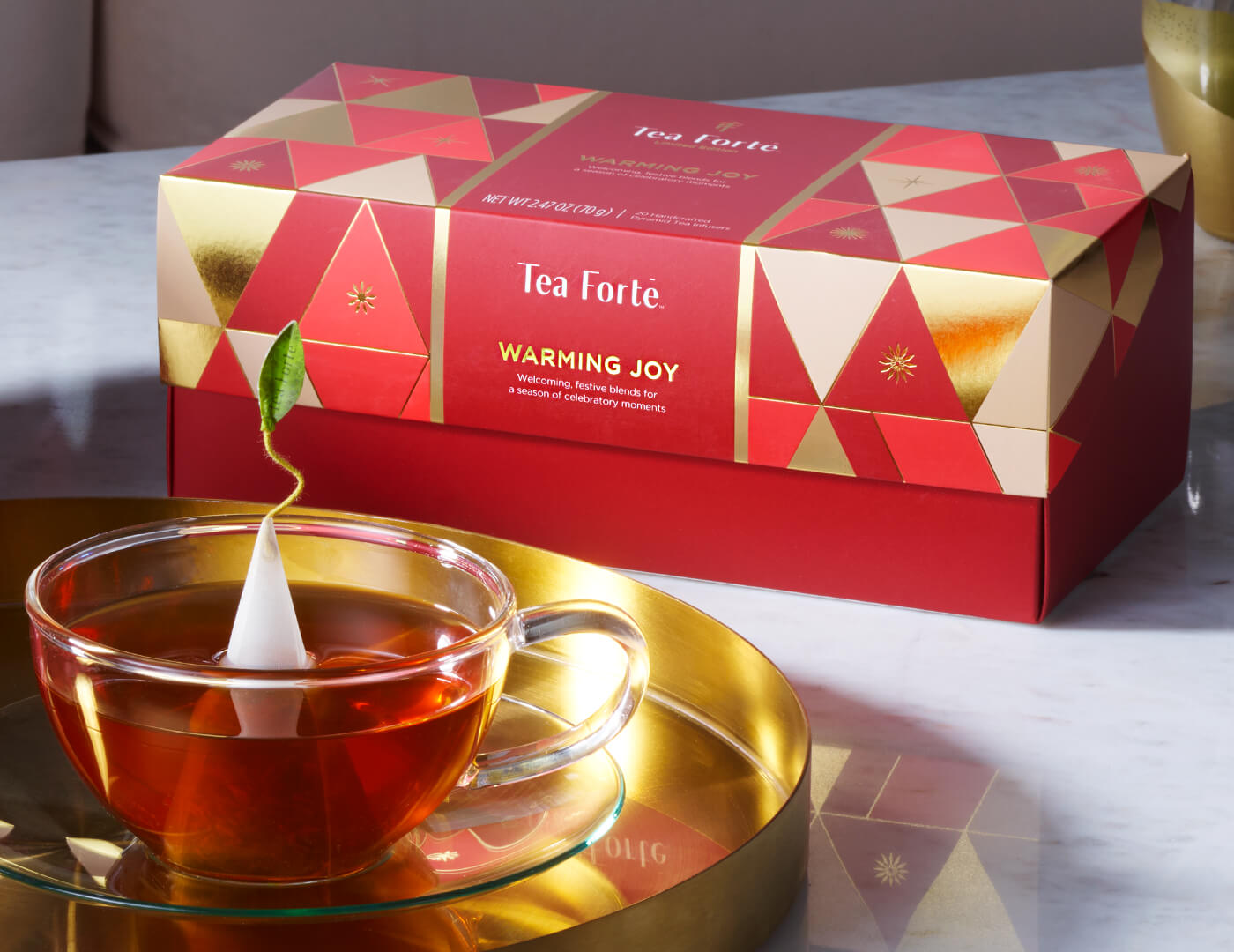 Image of Warming Joy Presentation Box next to Cup of Tea