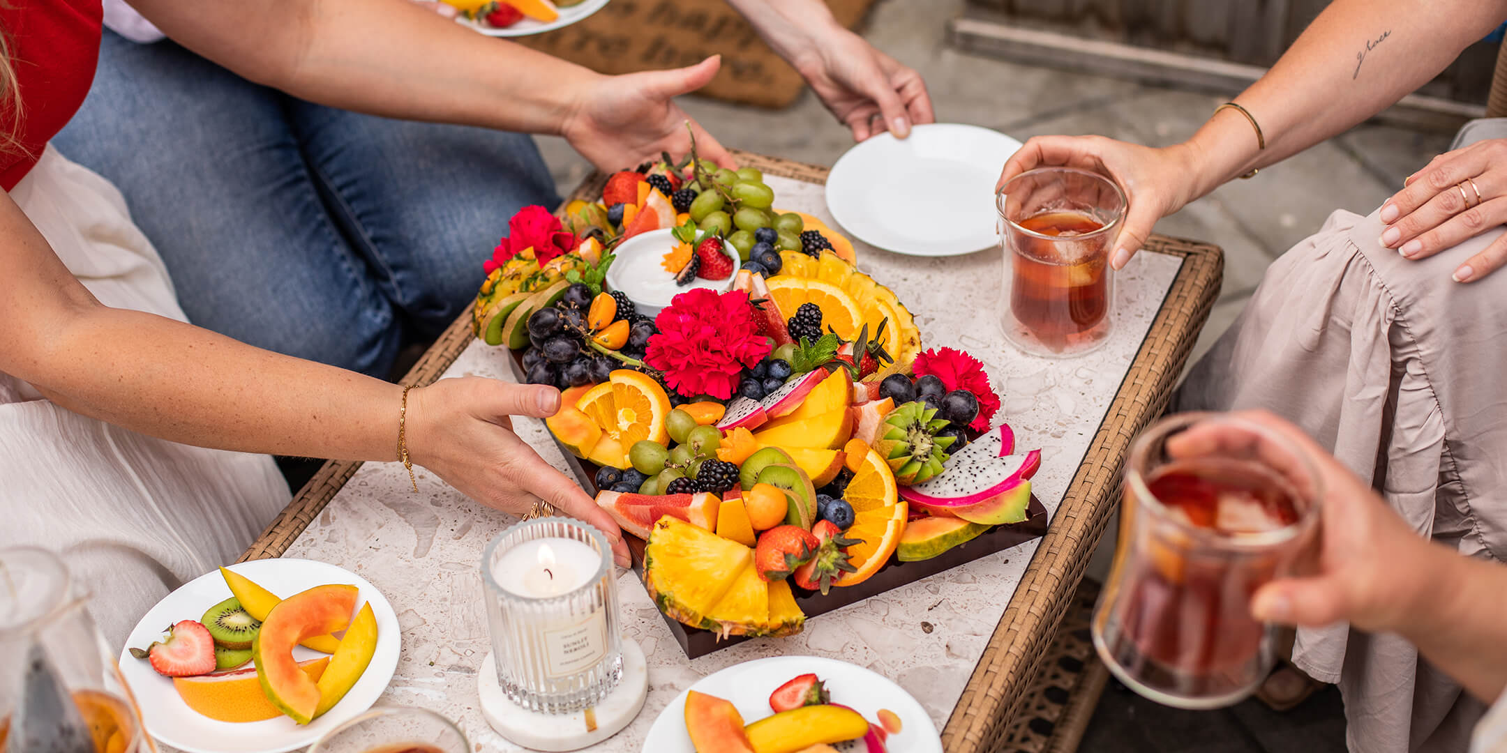 People gathered around a Graze Board of fruits