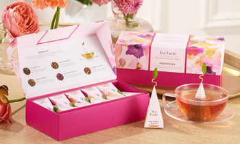 The Mariposa Collection Petite and Presentation Boxes, open and closed with fresh roses a glass cup of tea