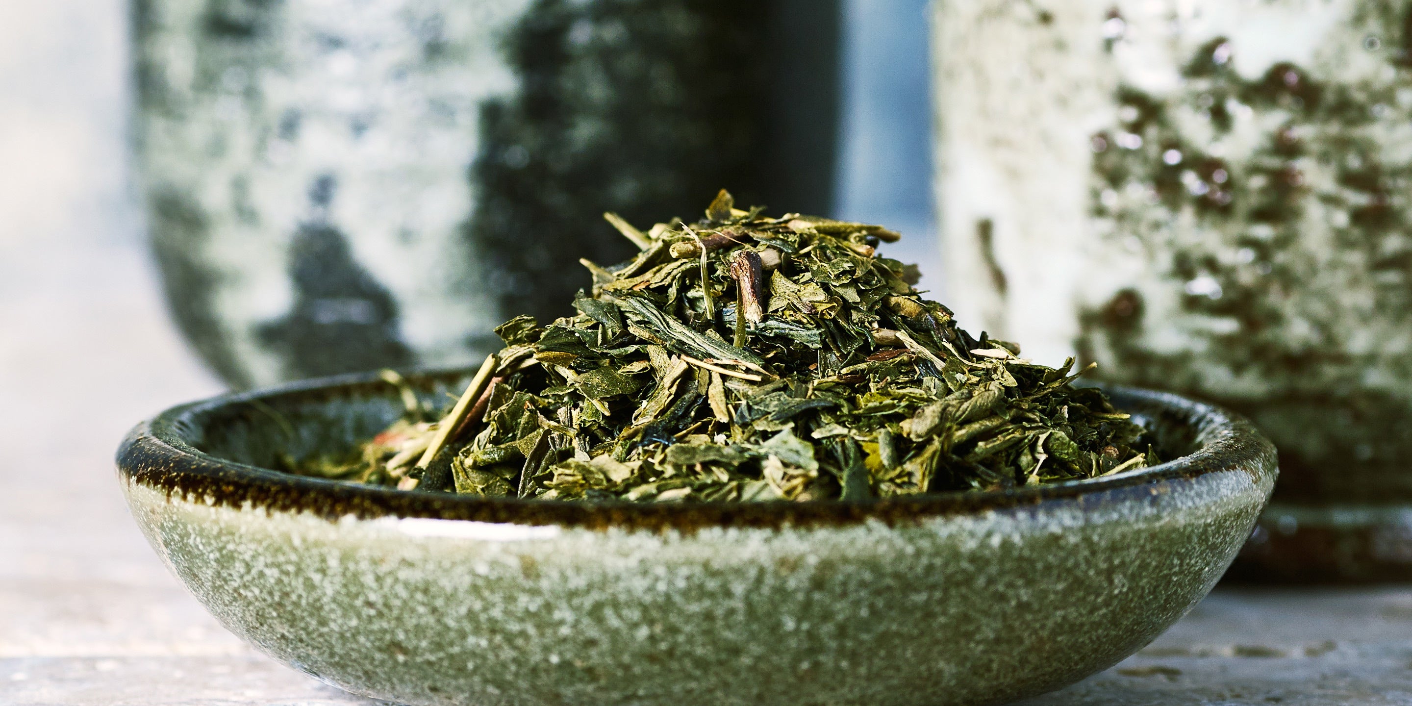 Small pile of sencha tea in a green ceramic bowl