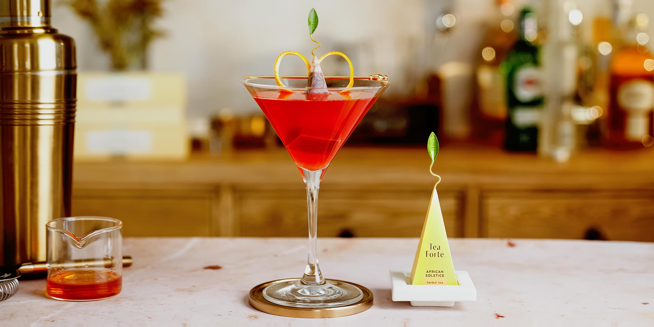 African Solstice Cosmopolitan in a martini glass with a pyramid infuser