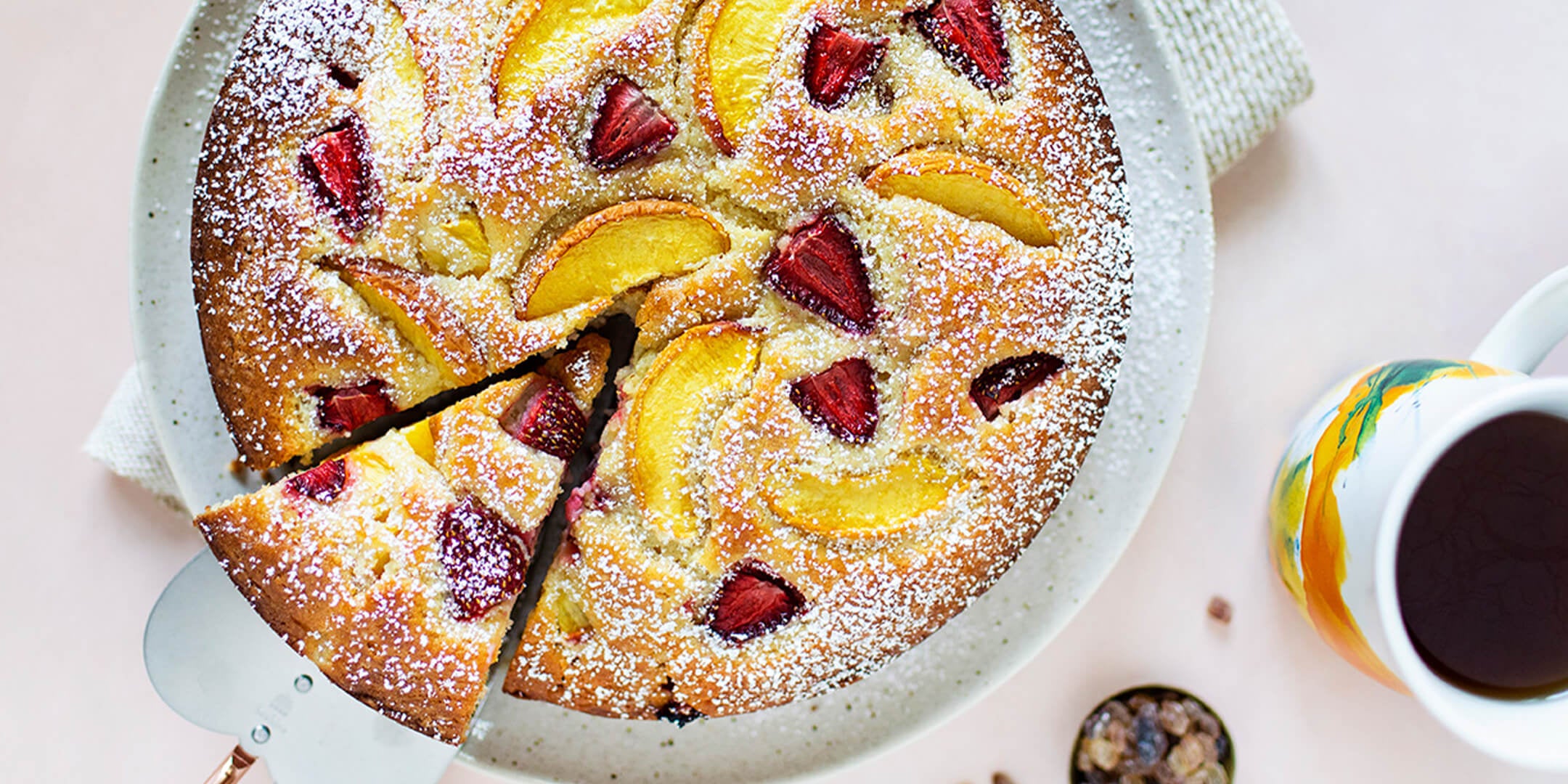 Taking a slice from a Peach Blossom & Strawberry Ricotta Cake